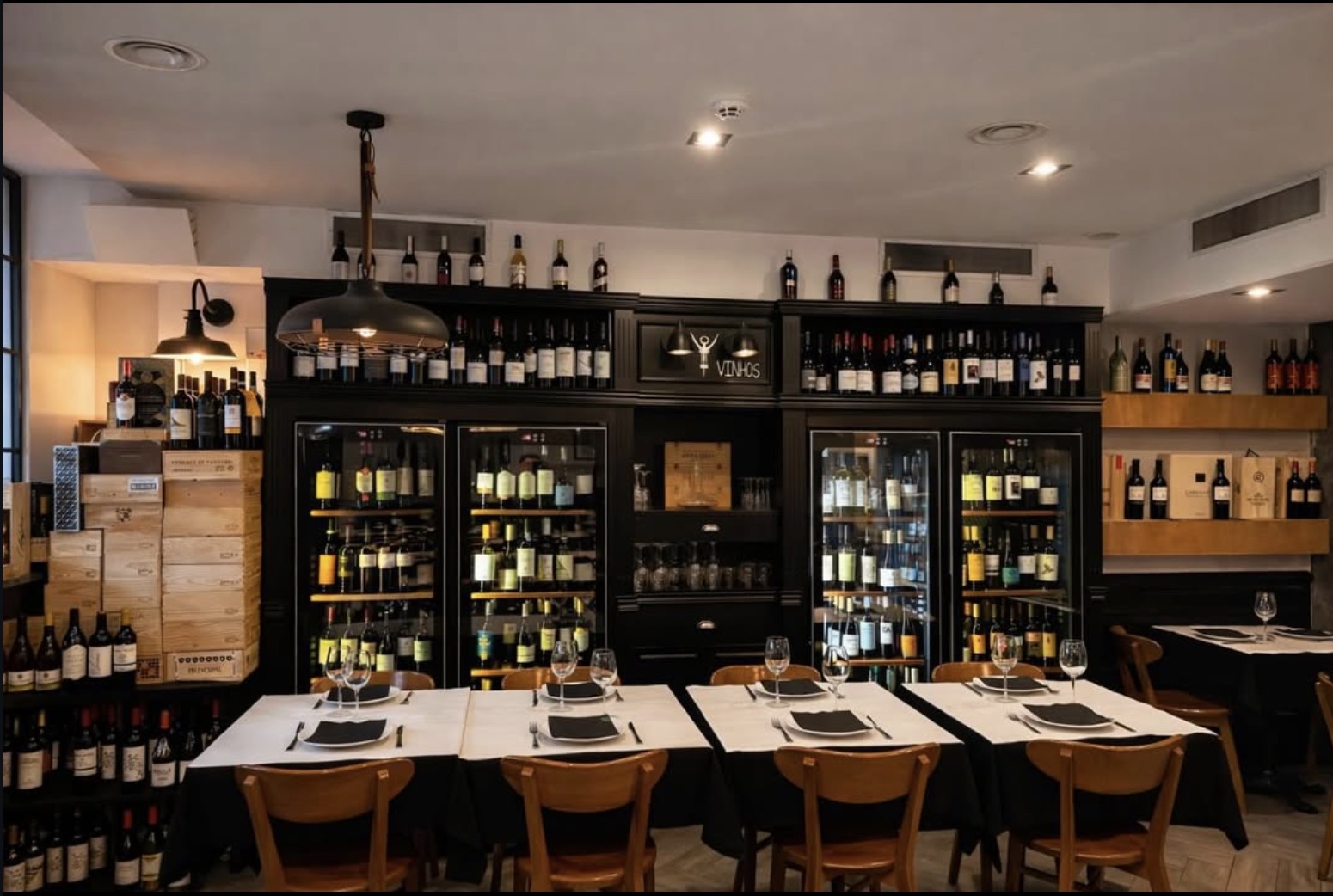 A garrafeira do Brasa do Bairro, com vinhos em vitrinas e caixas de madeira